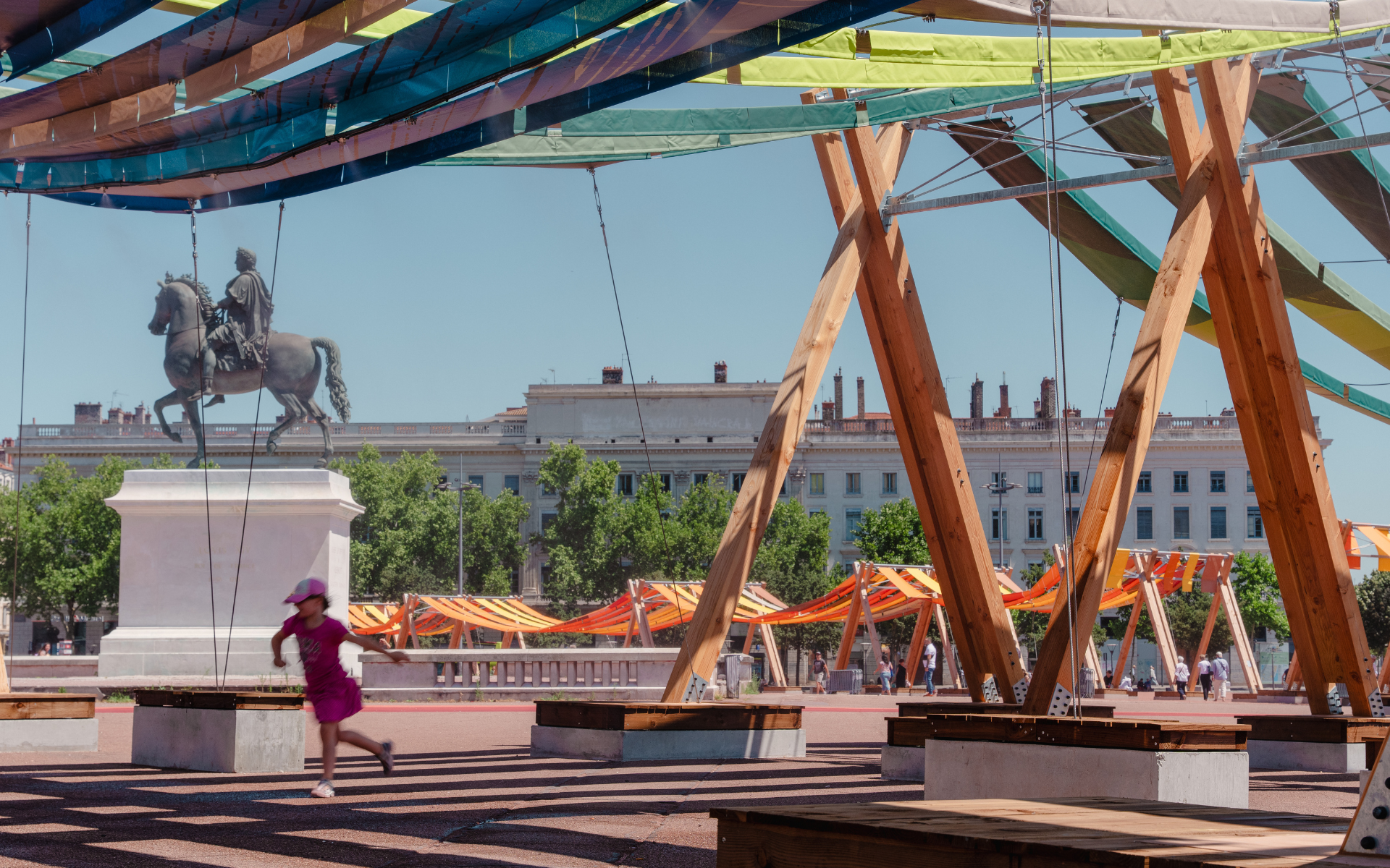 Une petite fille jouant sous l'&oelig;uvre Tissage urbain sur la place Bellecour. &copy;Jules Hidrot
